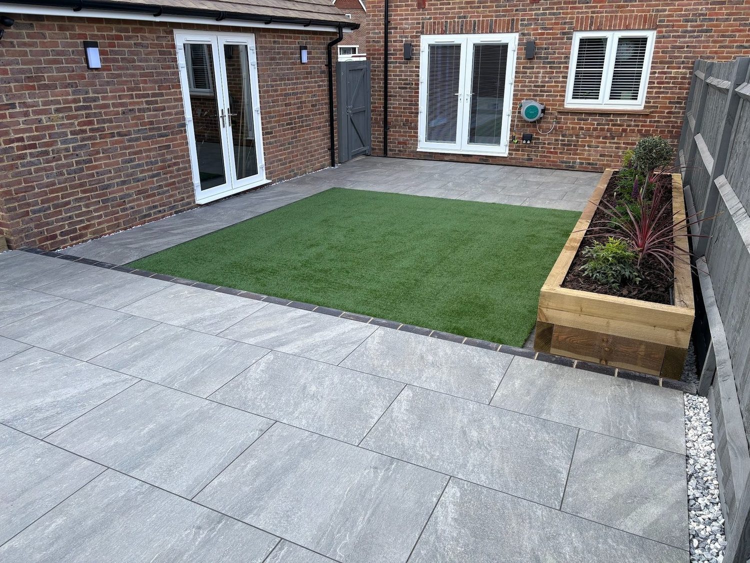 Porcelain terrace, sleeper planter and framed artificial lawn